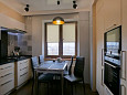 Фото ремонта кухни с светлыми фасадами и темной столешницей